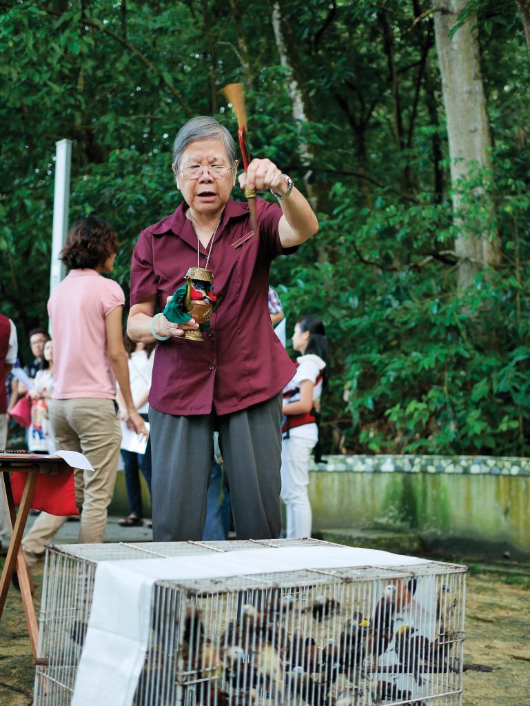 A senior Kechara pastor blessing birds before they are released during an Animal Liberation event.